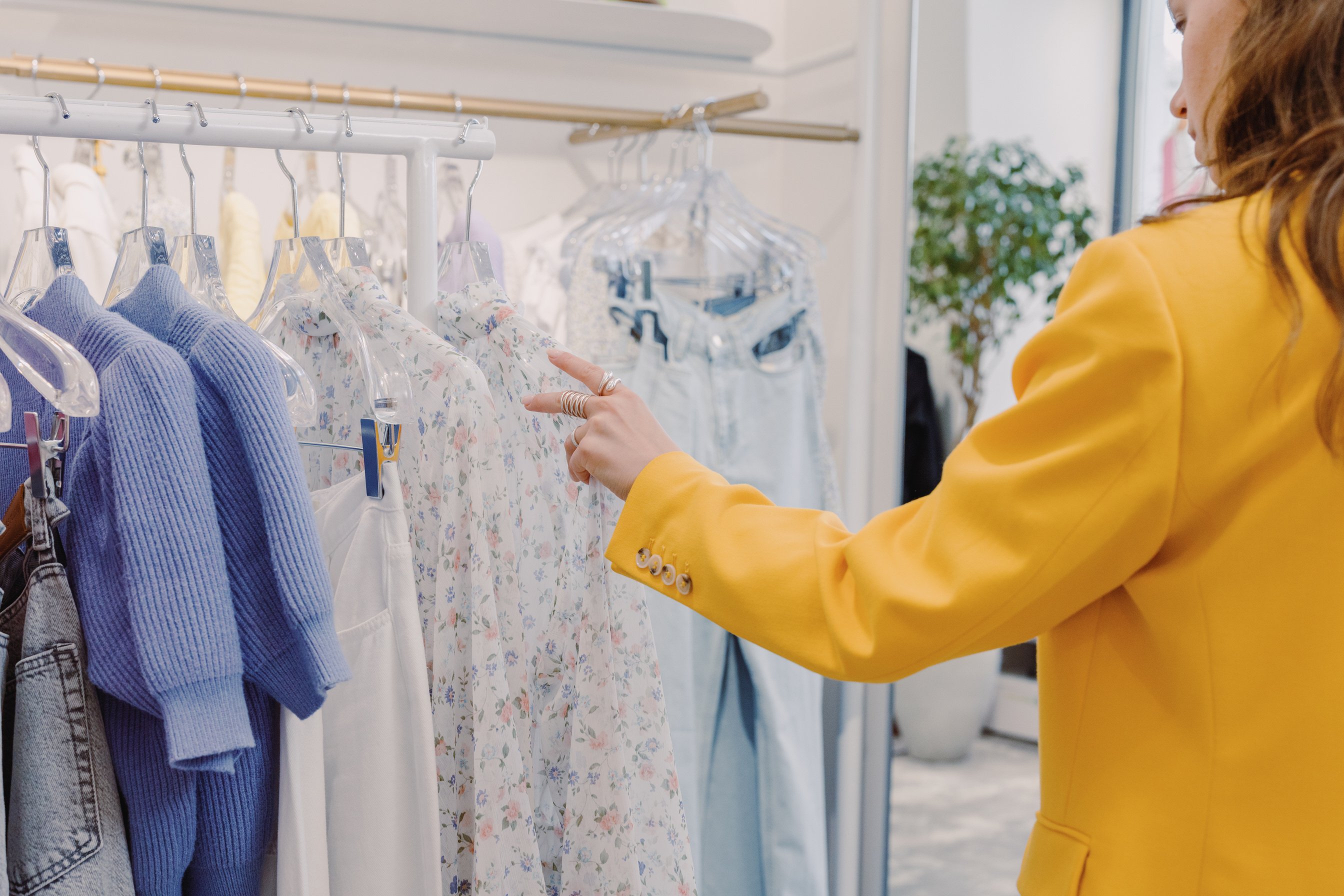 Person in Yellow Jacket Choosing Clothes